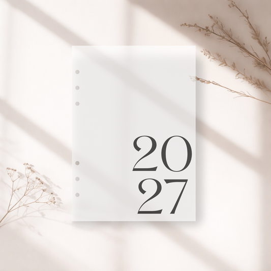 Frosted A5 6-Ring Dashboard with '2027' printed on it, placed on a light surface with dried plants.